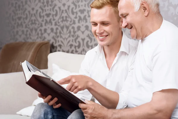 Grandfather and grandson sitting with album