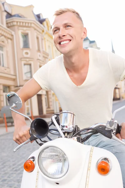 Smiling blond-haired man on scooter