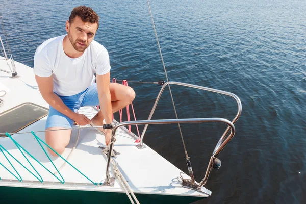 Positive man adjusting his yacht