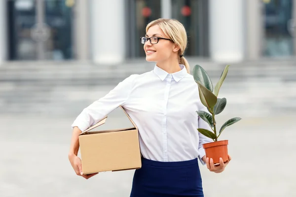 Nice businesswoman holding flower in a pot