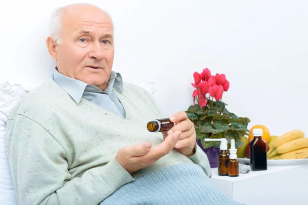 Elderly man holds his medicine vial.