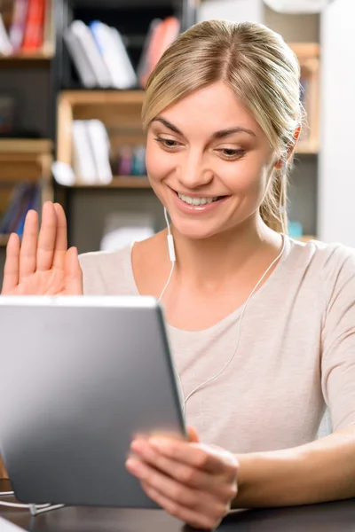 Girl waving at the tablet screen