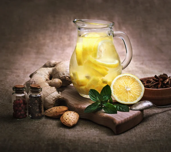 Ginger tea with lemon, ginger root and mint on rustic background