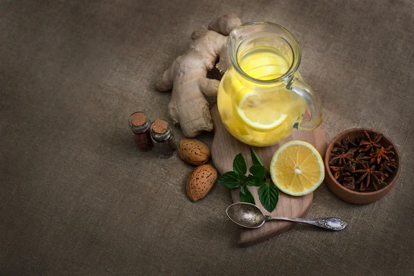 Ginger tea with lemon, ginger root and mint on rustic background