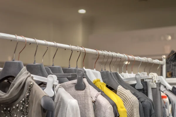 Clothes hang on a shelf in a clothes store