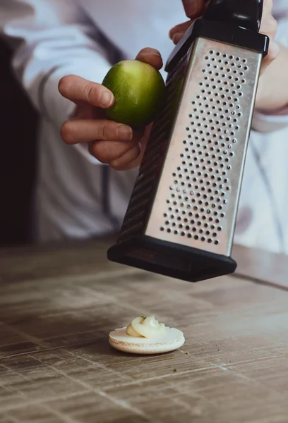 Close up of female pastry chef\'s hand cooking delicious macaroon