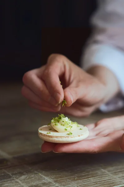 Close up of female pastry chef's hand cooking delicious macaroon