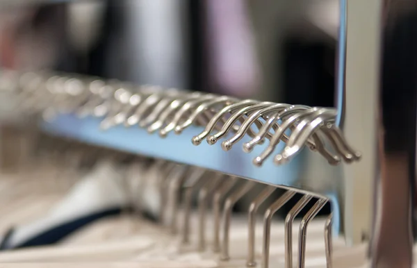 Clothes hang on a shelf in a clothes store