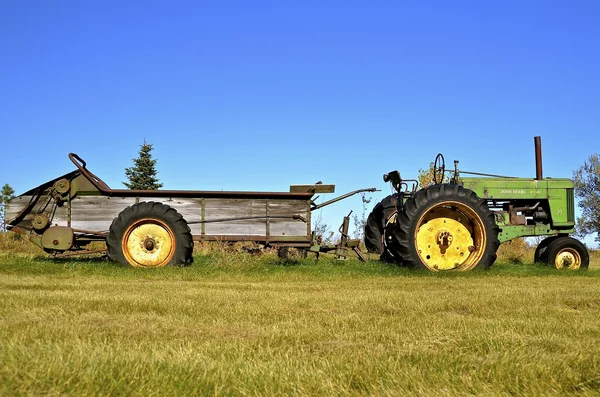 Old John Deere tractor pulling a manure spreader