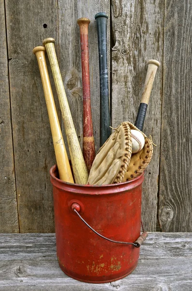 Vintage wood baseball bats in a pail