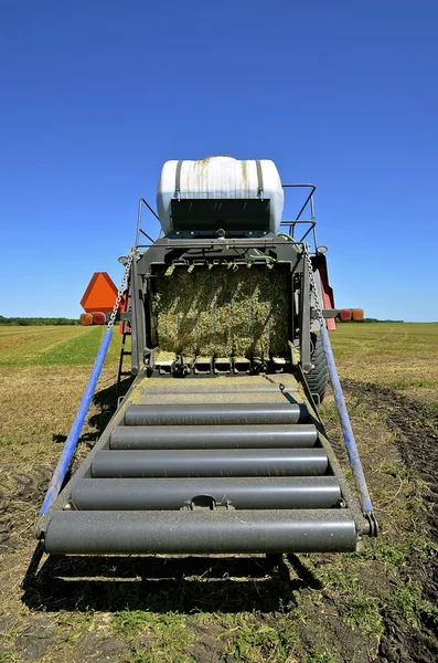 The rear rollers of a modern square hay baler