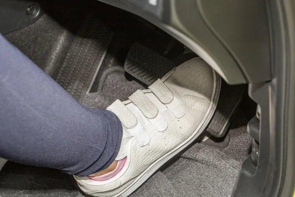Foot pressing the accelerate pedal of a car