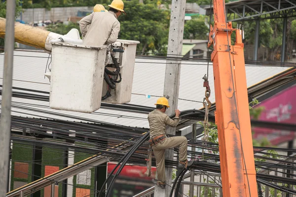 Electrician lineman repairman worker at climbing work on electri