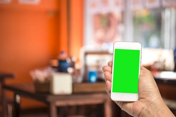 Hand holding smart phone over blur restaurant background, restau
