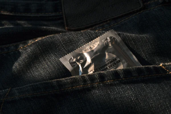 Condom in blue jeans pocket,Protect yourself Use a condom.a woma