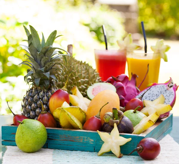 Assortment of tropical exotic fruits with smoothie and fresh juice