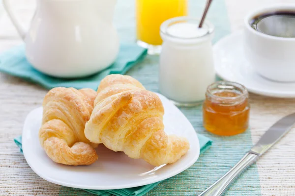 Romantic tropical breakfast Croissants, coffee, juice, honey and yogurt