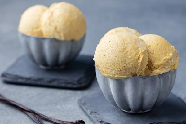 Vanilla Ice Cream with vanilla pods in metal vintage bowl.