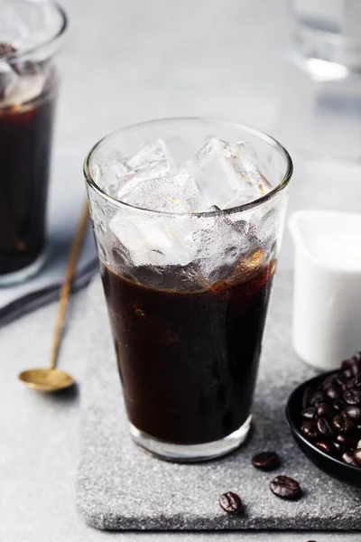Ice coffee in a tall glass and coffee beans