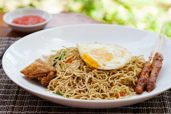 Nasi Goreng with fried egg, chicken Indonesian stir fried noodles Outdoor background