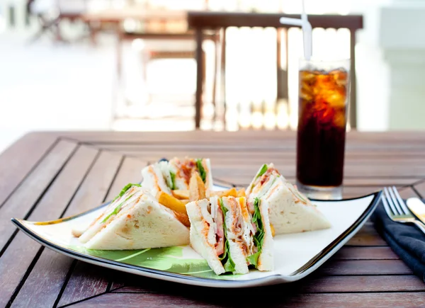 Club sandwich with iced soda drink