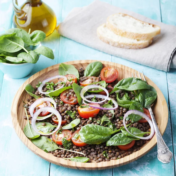 Lentil salad with cherry tomatoes, red onion and baby spinach.