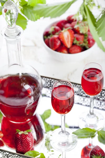 Strawberry and basil homemade liquor on a white background