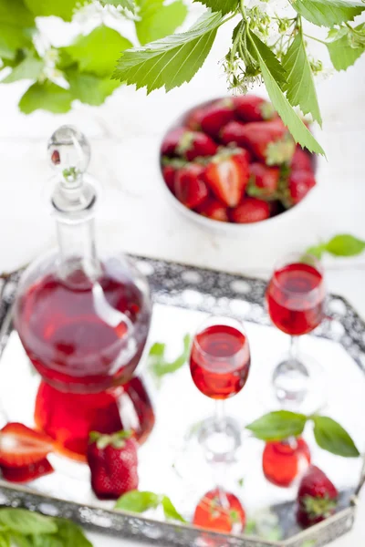 Strawberry and basil homemade liquor on a white background