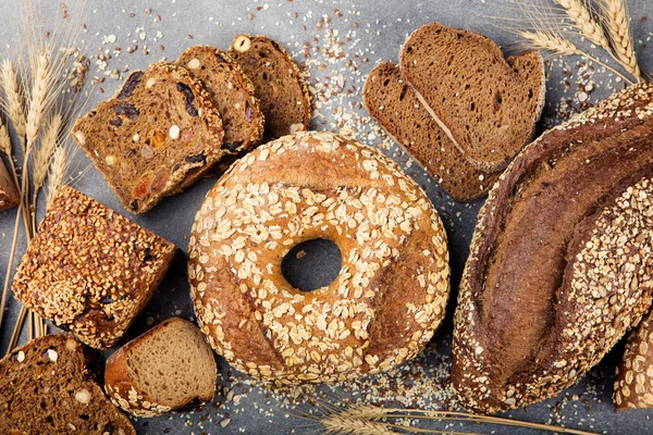 Assortment of baked bread on stone table background Composition with bread slices and rolls Copy space