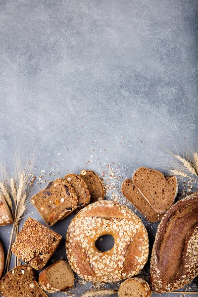 Assortment of baked bread on stone table background Composition with bread slices and rolls Copy space