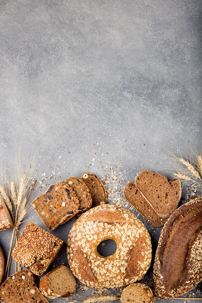 Assortment of baked bread on stone table background Composition with bread slices and rolls Copy space