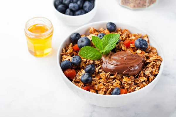 Healthy breakfast Fresh granola, muesli in bowl with milk, berries, chocolate hazelnut spread Copy space