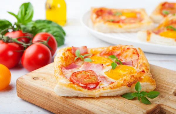 Fresh homemade square Pizza with vegetables and basil on cutting board