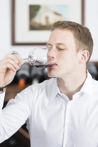 Man tasting a glass of red win
