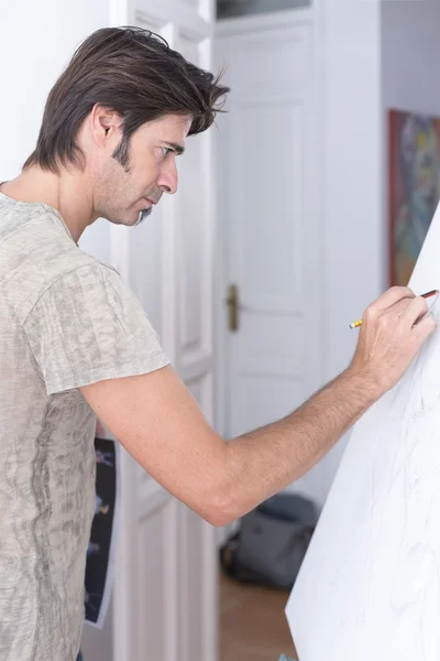 Young man drawing on canvas - painting session
