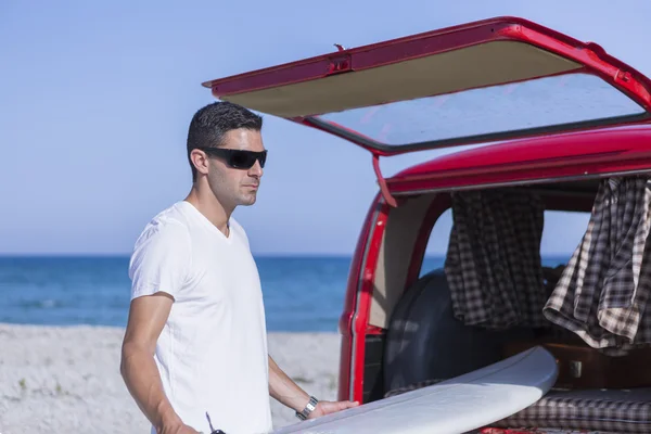 Young male surfer taking a surf board