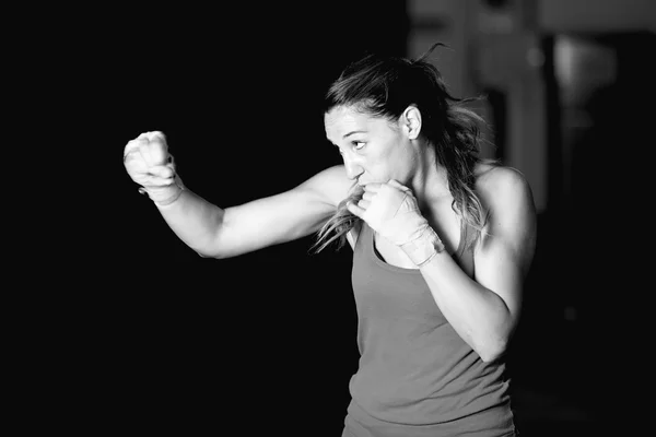 Muscular female boxer practicing strokes