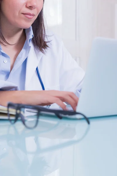 Close-up of doctor working on laptop