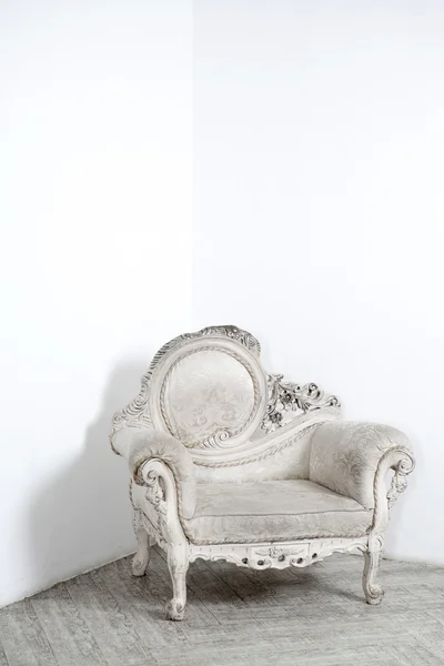 Beautiful antic armchair from solid wood in white interiour