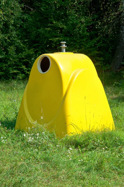 Yellow garbage container in the forest