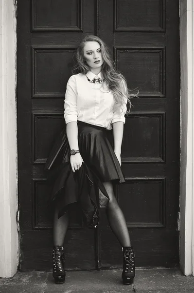 Black and white photography. Model in a black leather skirt and