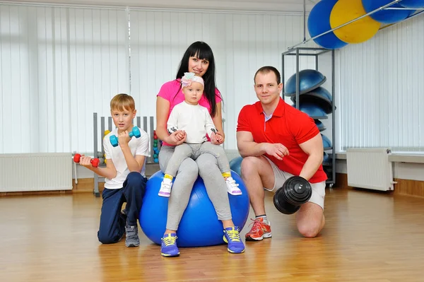 Happy family in fitness club. Happy sporty family