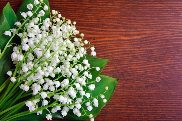 Bouquet of lilies of the valley on the wooden board