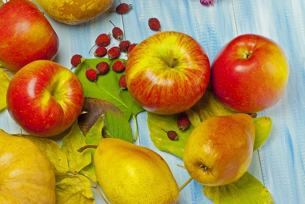 Ripe apples and pears on a wooden background