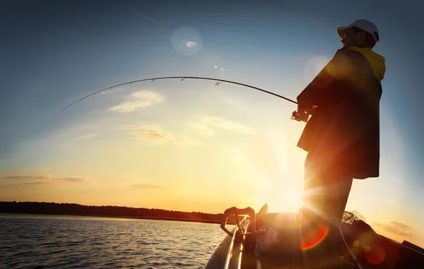 Man fishing over sunset