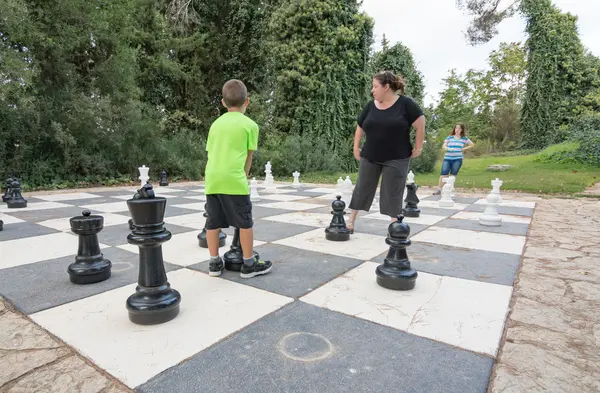 Sister and brother playing giant outdoor chess