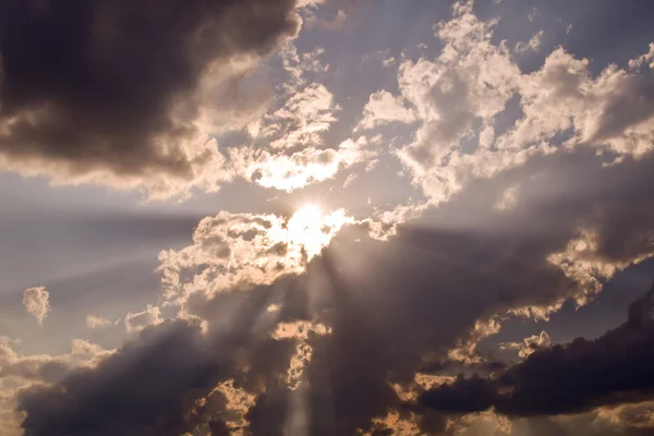 Sky with rain storm clouds and sun ray at sunset time