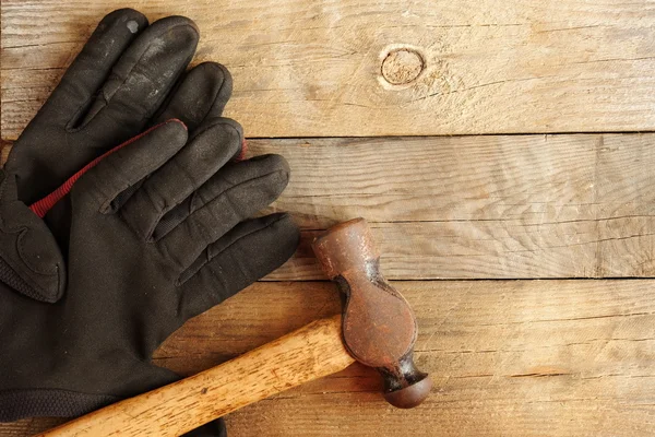 Sledgehammer and leather gloves on wood Background. Top View of Sledge Hammer with Wooden Handle and black leather glove.