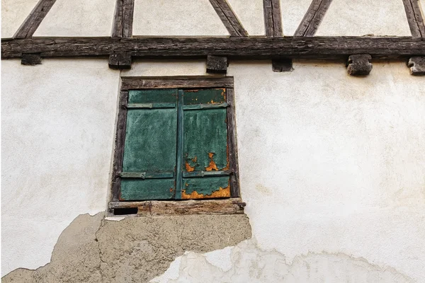 Fragment of an old half-timbered house with window shuttered