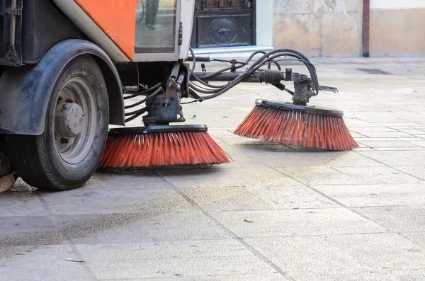 Vehicle sweeping the streets of dirt.